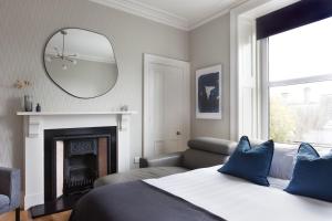 a bedroom with a bed and a mirror and a fireplace at Esslemont Pad in Aberdeen