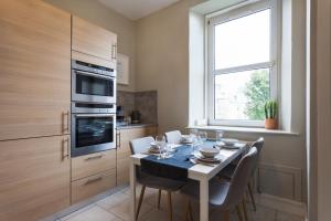 cocina con mesa con sillas y ventana en Esslemont Pad, en Aberdeen