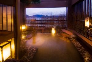 a room with a large window with a hot tub at Dormy Inn Premium Shimonoseki in Shimonoseki