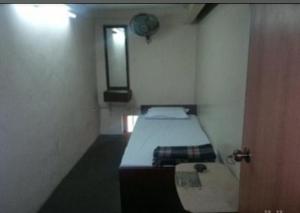 a small room with a bed and a window at Continental Guest House in Kolkata