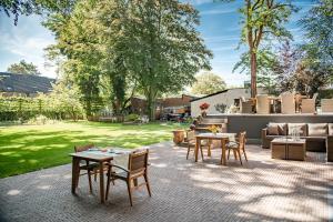 een patio met tafels en stoelen in een tuin bij B&B Parkhuys in Antwerpen