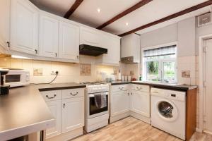 een keuken met witte kasten en een wasmachine en droger bij Silver Stag Properties, 2 BR Home in Town Centre in Ashby de la Zouch