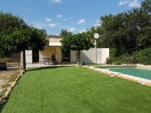 un patio con piscina y una persona sentada en una silla en MARTIN's COTTAGE Tourrettes en Tourrettes