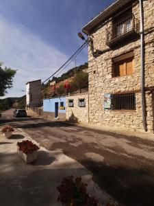 un edificio de piedra al lado de una calle en Casa Rural y Albergue Tormon en Tormón