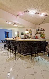 un bar en una habitación con sillas alrededor en Trianta Hotel Apartments en Ialyssos