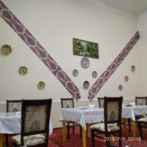 a dining room with tables and plates on the wall at Mubina Khiva B&B in Khiva