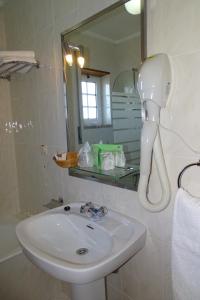 a bathroom with a white sink and a mirror at Hotel Mira Rio in Esposende