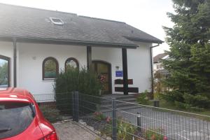 una casa con una macchina rossa parcheggiata di fronte di Ferienwohnung Angelika a Degerfelden