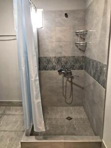 ein Bad mit einer Dusche, einem Waschbecken und einer Dusche in der Unterkunft Season in Kutaissi