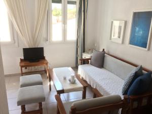 a living room with a couch and a tv at Angies House in Skopelos Town