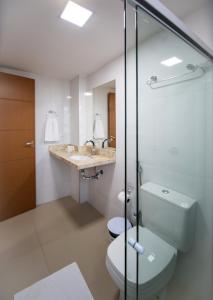 a bathroom with a toilet and a sink at Tambau Beach Hotel in João Pessoa