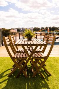 a wooden picnic table with two chairs and a potted plant at The Turner Apartment - Margate Beach - By Goldex Coastal Breaks in Margate