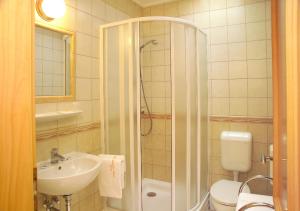 a bathroom with a shower and a sink and a toilet at Vadászkürt Panzió és Étterem in Sopron