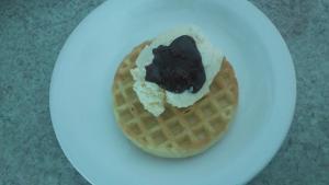 a waffle with ice cream on a white plate at Pousada Gaia in Macaé