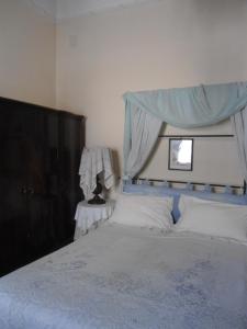 - une chambre avec un lit à baldaquin bleu dans l'établissement Rosella Bianchi, à Palerme