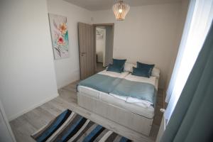 a small bedroom with a bed with blue pillows at Francesca Apartman in Siófok