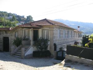 una casa de piedra con una escalera delante de ella en Casa De Carcavelos en Cabeceiras de Basto