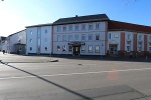 an empty street with a large white building at Hotel Deutscher Hof in Babenhausen