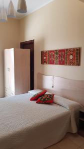 Un dormitorio con una cama con almohadas rojas. en B&B Villa VITTORIO en Nardò