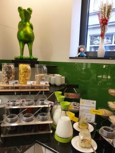 a kitchen with a green cat on a counter with food at Hotel Am Kaisersaal in Erfurt