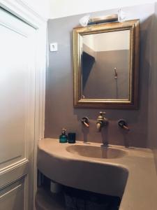 uma casa de banho com um lavatório e um espelho em Appartement Zeeuws genoegen em Vlissingen