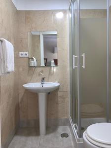 a bathroom with a sink and a shower and a toilet at Residencial Lord in Lisbon