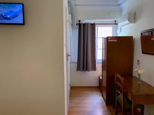 a room with a table and a refrigerator and a window at Residencial Lord in Lisbon