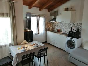 a kitchen with a table with chairs and a washing machine at Borgo Foce La Spezia SP2389 in La Foce
