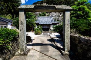 a stone archway in front of a building at Oteragoto in Goto