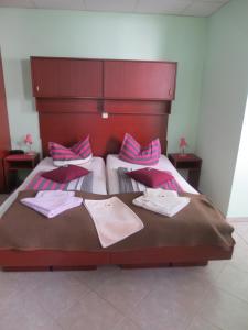 two beds in a bedroom with pink and purple pillows at Pension Barghus in Zinnowitz