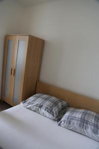 a bed with a pillow and a cabinet in a room at Praha 2 in Prague