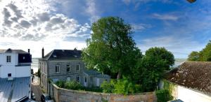an old building and a stone wall with trees at L’Heure Bleue in Le Crotoy