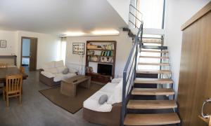 a living room with a spiral staircase in a house at A casa do viveiro in Dormeá