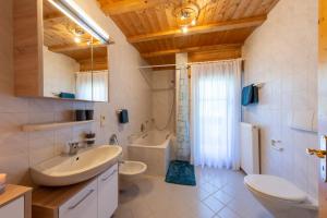 a bathroom with a sink and a toilet and a tub at Ferienwohnungen Oberweier in Merano +22 photos