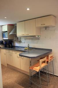 a kitchen with a counter and a sink and two chairs at Casa Susanne in Berlin