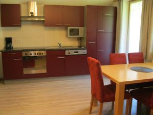 une cuisine avec une table en bois et une salle à manger dans l'établissement Appartement Geisler, à Zell am Ziller