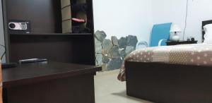 a bedroom with a bed and a desk with a clock at Marina's Rooms in Larnaca