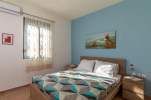 1 dormitorio con 1 cama con pared azul en House Myrtos en Lakhania
