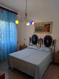 ラーカレにあるCasa Della Nonnaのベッドルーム1室(青いカーテンとシャンデリア付きのベッド1台付)