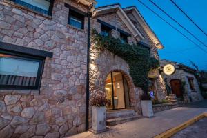 a stone building with a clock on the side of it at Posada Güemes BOUTIQUE in Mar del Plata