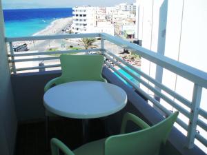 a table and chairs on a balcony with the beach at Nafsika Hotel in Rhodes Town