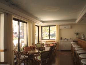 a dining room with tables and chairs and windows at Nafsika Hotel in Rhodes Town