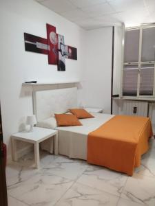 Un dormitorio con una cama y una mesa. en Albergo Ollolai, en Civitavecchia