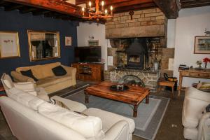 a living room with a couch and a fireplace at La Maison du Chene in Percy