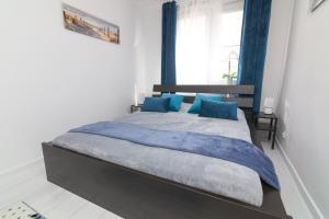 a bedroom with a large bed with blue pillows at Wave in Hel in Hel