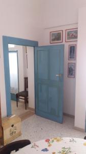 una stanza con una porta blu in una stanza di Appartamento in palazzina storica / Oberdan Suites ad Alberobello