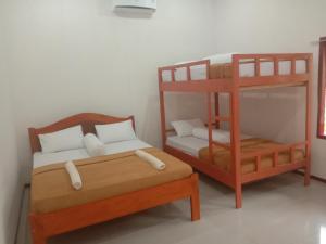 um quarto com 2 beliches e uma cama em Riung Guesthouse em Riung