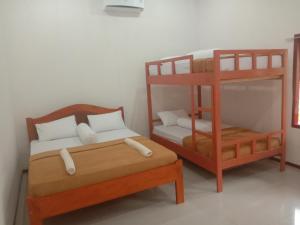 Cette chambre comprend deux lits superposés et un lit. dans l'établissement Riung Guesthouse, à Riung