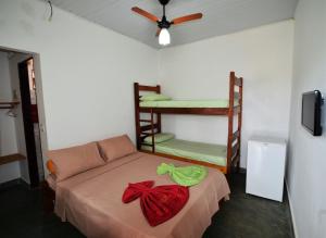 レンソイスにあるDoce Lar Hospedariaのベッド1台、ソファ、ファンが備わる客室です。