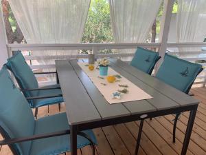 a table with blue chairs and oranges on a deck at LunaSky Murter Mobile Home in Jezera